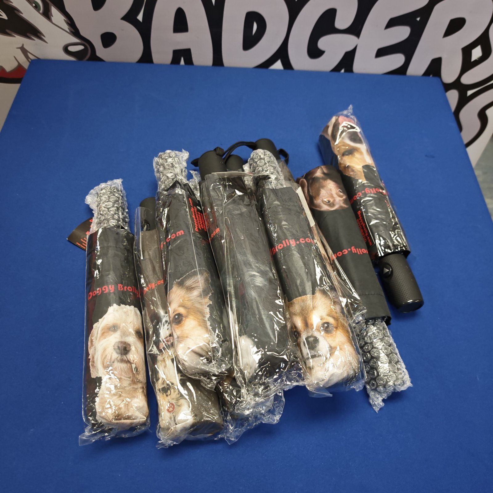Bundle of unused dog umbrellas with animal print designs.
