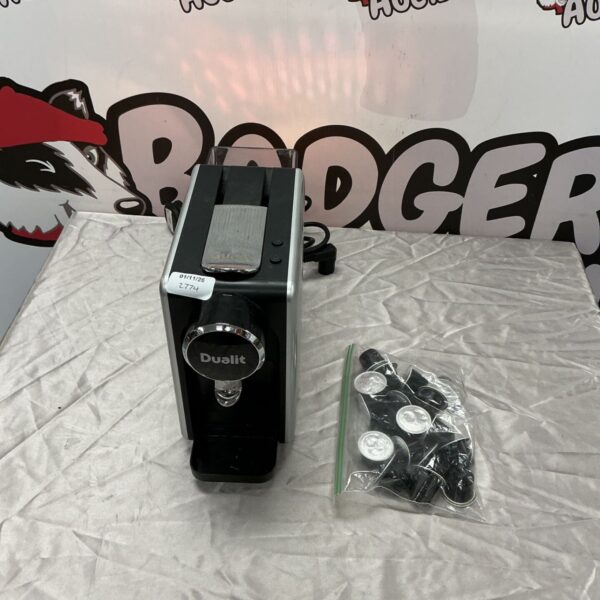 Black and silver Dualit coffee machine beside a bag of pods