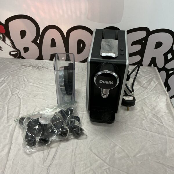 Dualit black and silver coffee machine with clear water reservoir and bag of pods
