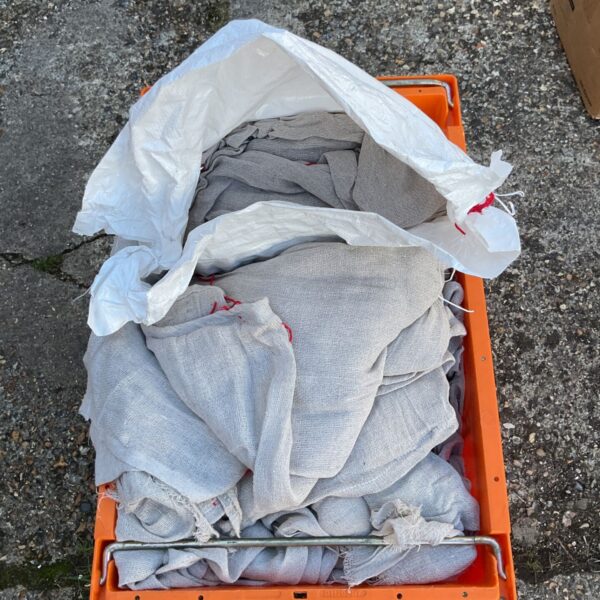 Box filled with used linen dust sheets for painting and protection.