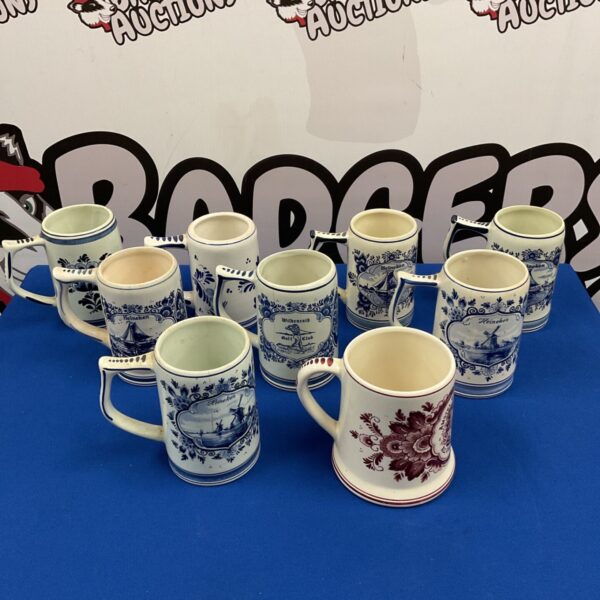 Group of nine Dutch Delft blue and white ceramic tankards with Heineken designs