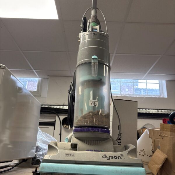Dyson DC04 upright bagless vacuum cleaner with clear dust container on a table