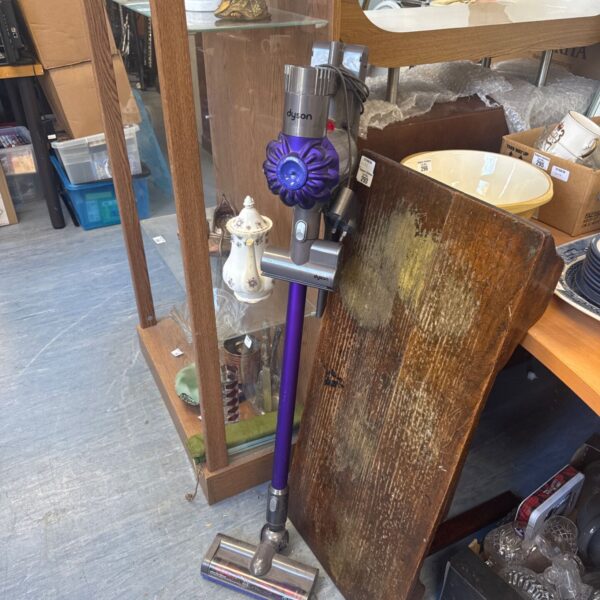 Dyson V6 Animal cordless vacuum cleaner with cradle and attachments.