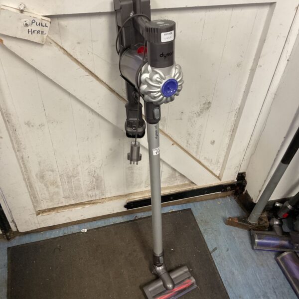 Dyson V6 cordless stick vacuum cleaner with motorised floor head against white door