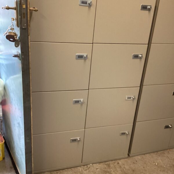 Grey metal eight door locker unit with combination locks on each door