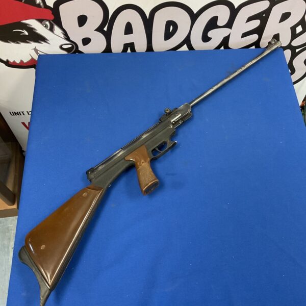 El Gamo .177 air rifle with dark metal body and brown stock on blue surface