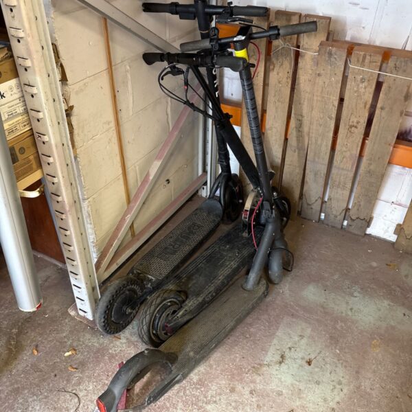 Three electric scooters for repair, including a Pure scooter.
