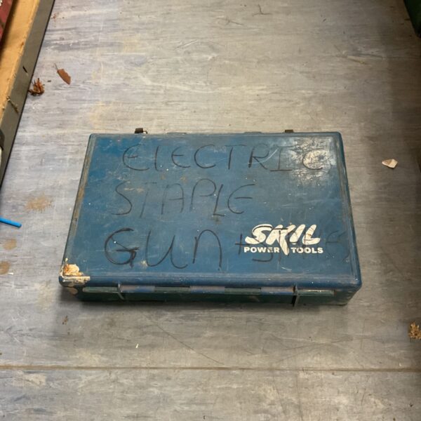 Vintage electric staple gun in its original plastic carrying case.