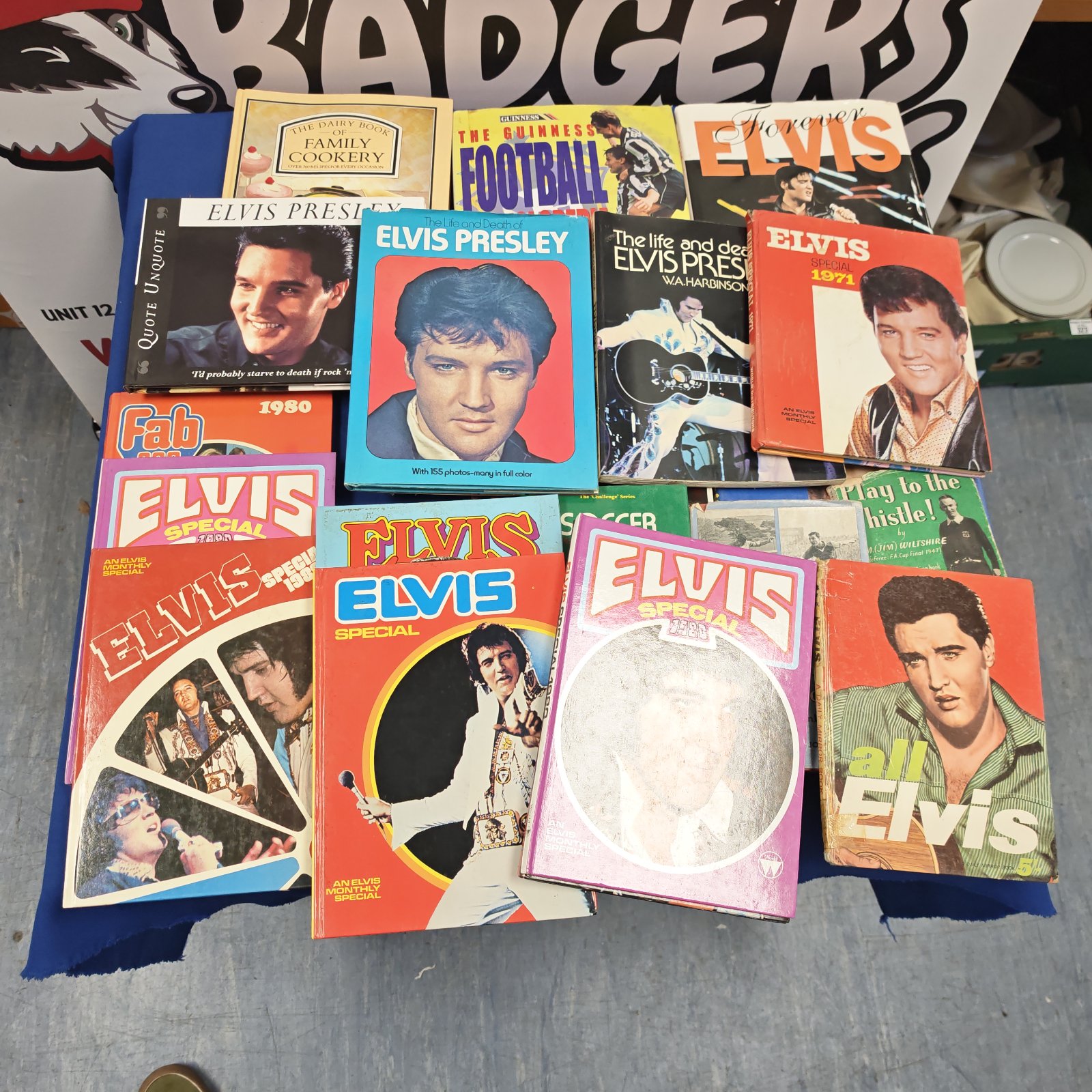 Box lot of Elvis Presley books, annuals and football books laid out on a table