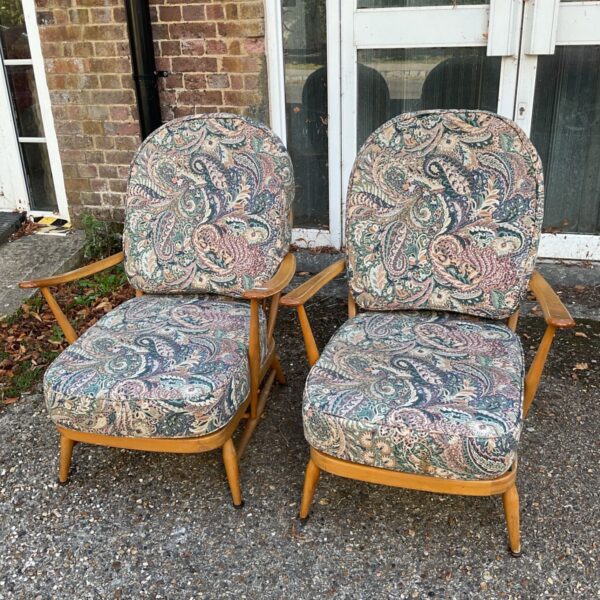 Pair of vintage Ercol armchairs with patterned upholstery.