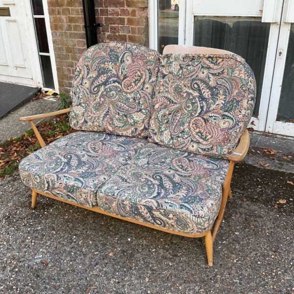 Vintage Ercol settee with patterned upholstery and stickback design.
