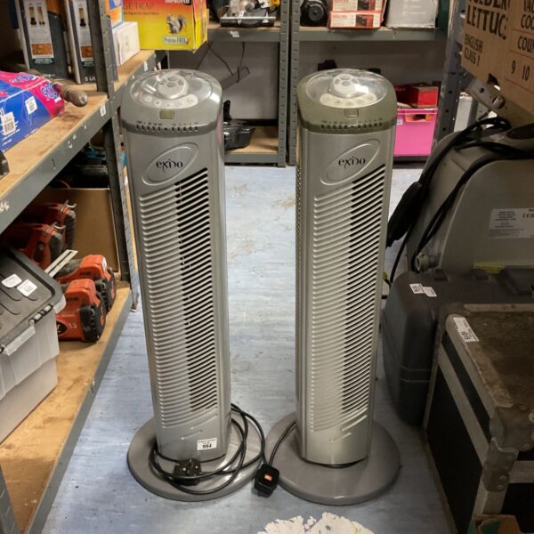 Pair of vintage Exido tower fans in a workshop setting.