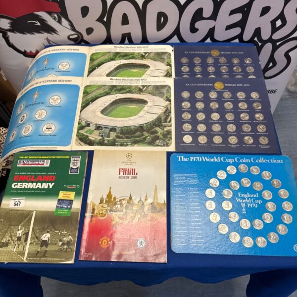 FA Cup centenary coin boards, 1970 World Cup coin collection and football programmes laid out on a table