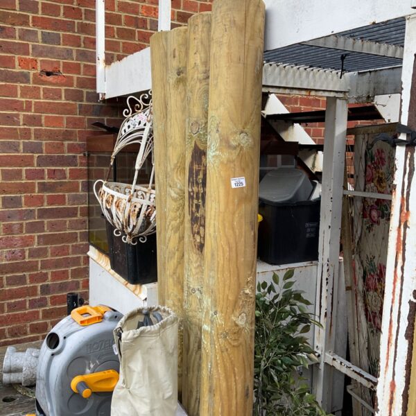 Lot of four large round wooden fence posts for garden projects.
