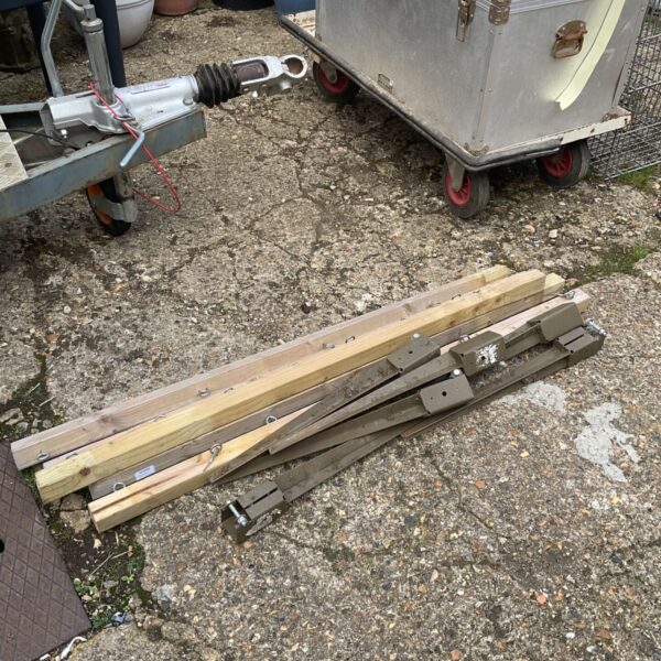 Weathered fence posts with metal spike fixings for garden use.