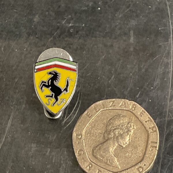 Vintage Ferrari enamel badge with prancing horse logo.