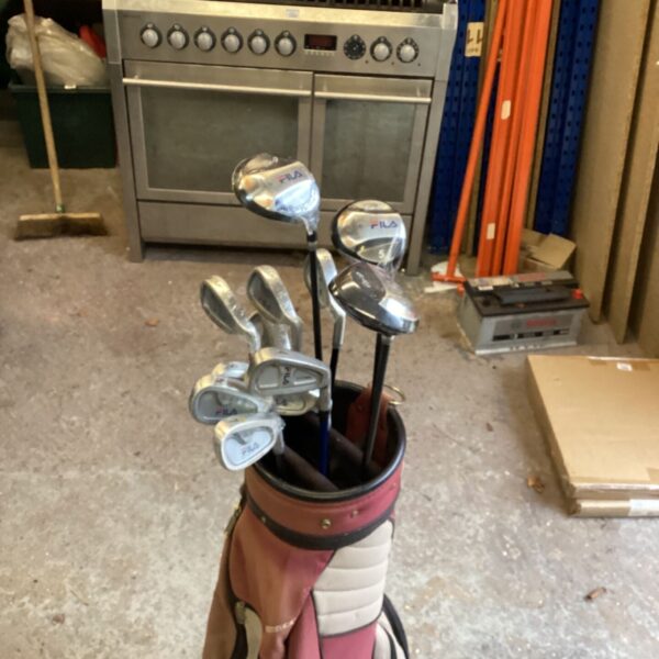Fila golf clubs with woods and irons in a maroon golf bag