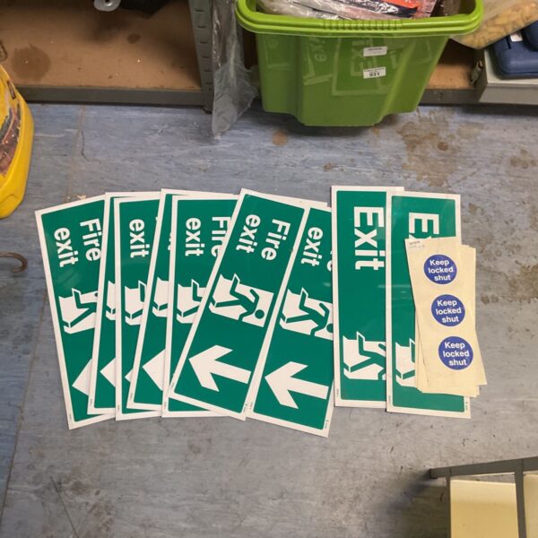 Bundle of green fire exit signs and keep locked shut stickers