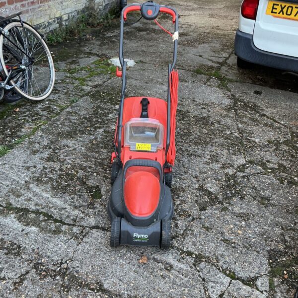 Red and black Flymo Chevron 32VC electric lawn mower with coiled mains cable