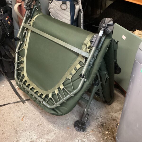 Green folding fishing bed with metal frame and webbing straps