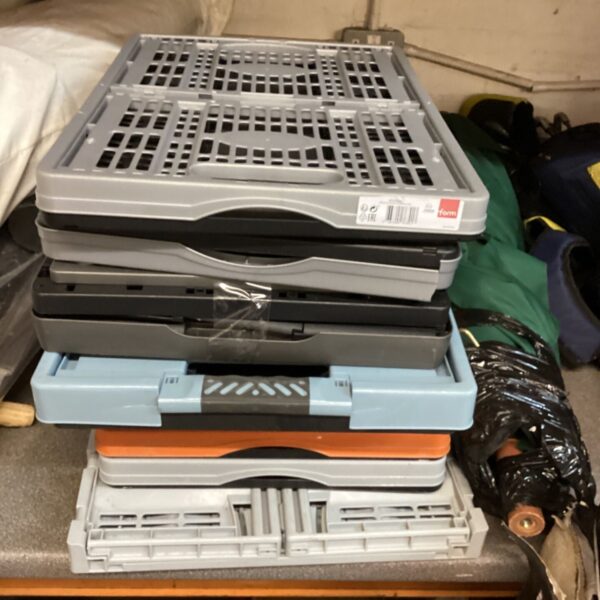 Stack of mixed colour folding plastic storage crates in grey, black, blue and orange