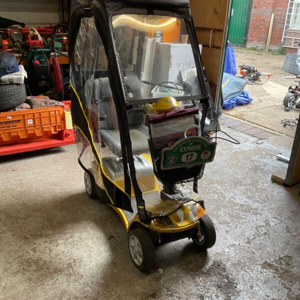 Yellow Foru mobility scooter with clear weather cover.