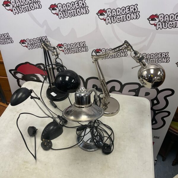 Four desk reading lamps in black and chrome finishes on a table