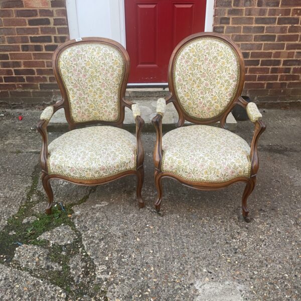 Vintage French Louis XV armchairs with floral upholstery and carved wood.