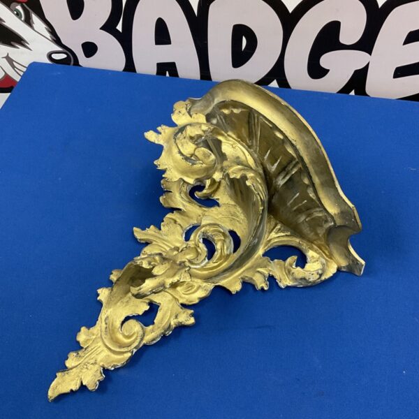 French rococo style gilded wall shelf with ornate acanthus scrollwork and shell-shaped back