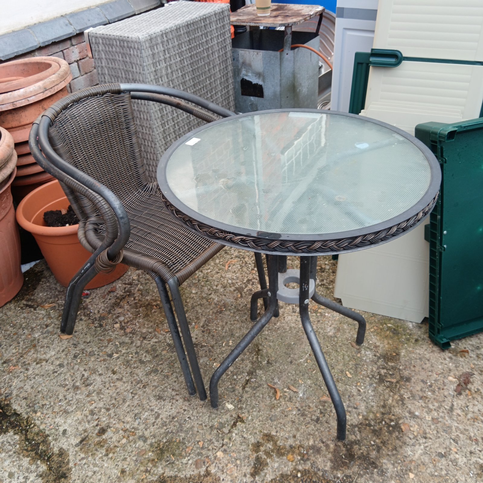 Dark wrought iron garden table and two chairs with glass top.