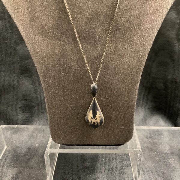 Silver Gemini zodiac pendant necklace on display.