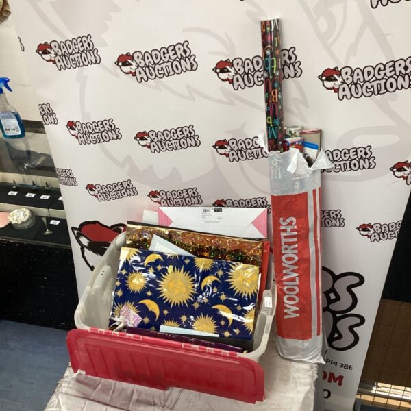 Storage box of gift bags with rolls of wrapping paper beside it