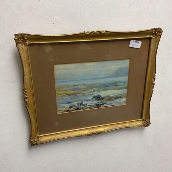Gilt framed watercolour seascape showing low tide rocks and distant headland