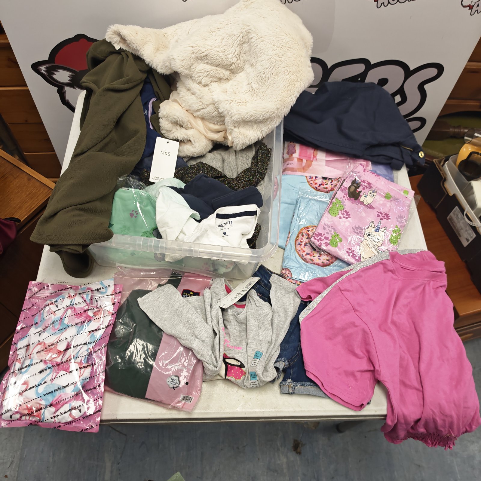 Mixed tray of girls clothing with satin nightwear, denim shorts and sealed packs