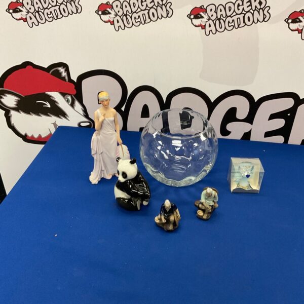 Glass globe display dome with porcelain panda figurines inside.