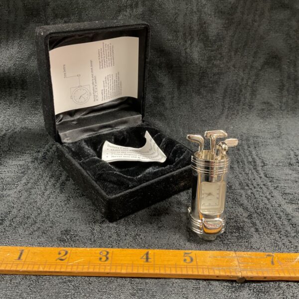 Silver-tone golf club bag quartz desk clock beside its black velvet presentation box