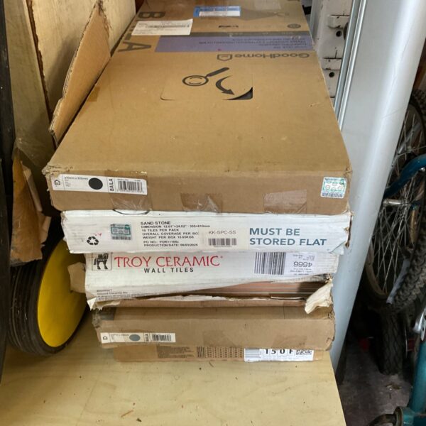 Stack of beige ceramic floor tiles in original packaging.