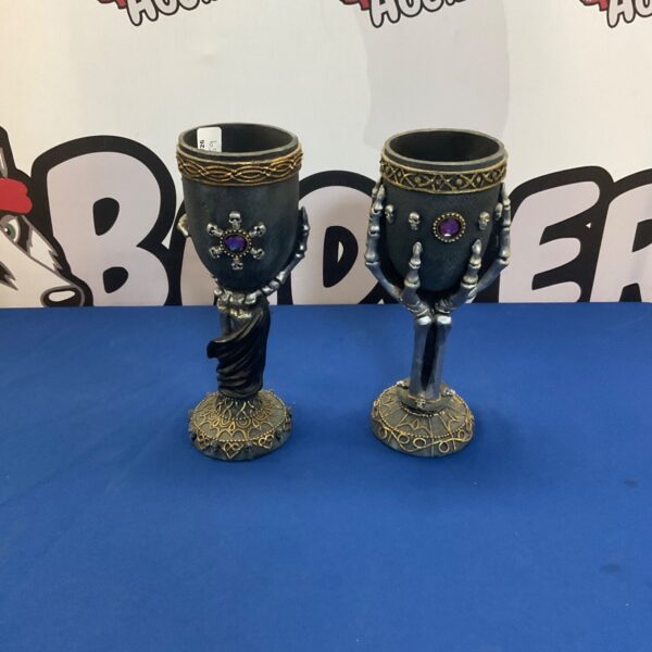 Pair of dark gothic goblets with skull bases for display.