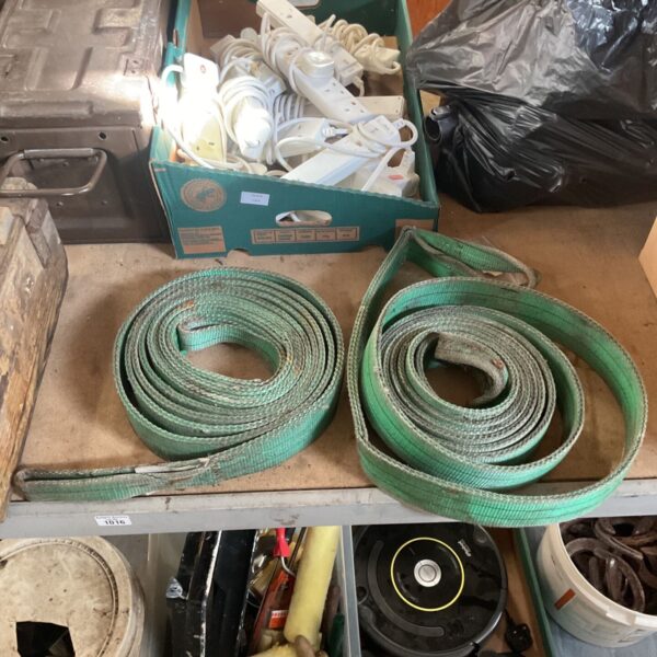 Pair of rolled green duplex flat woven webbing lifting slings on a shelf