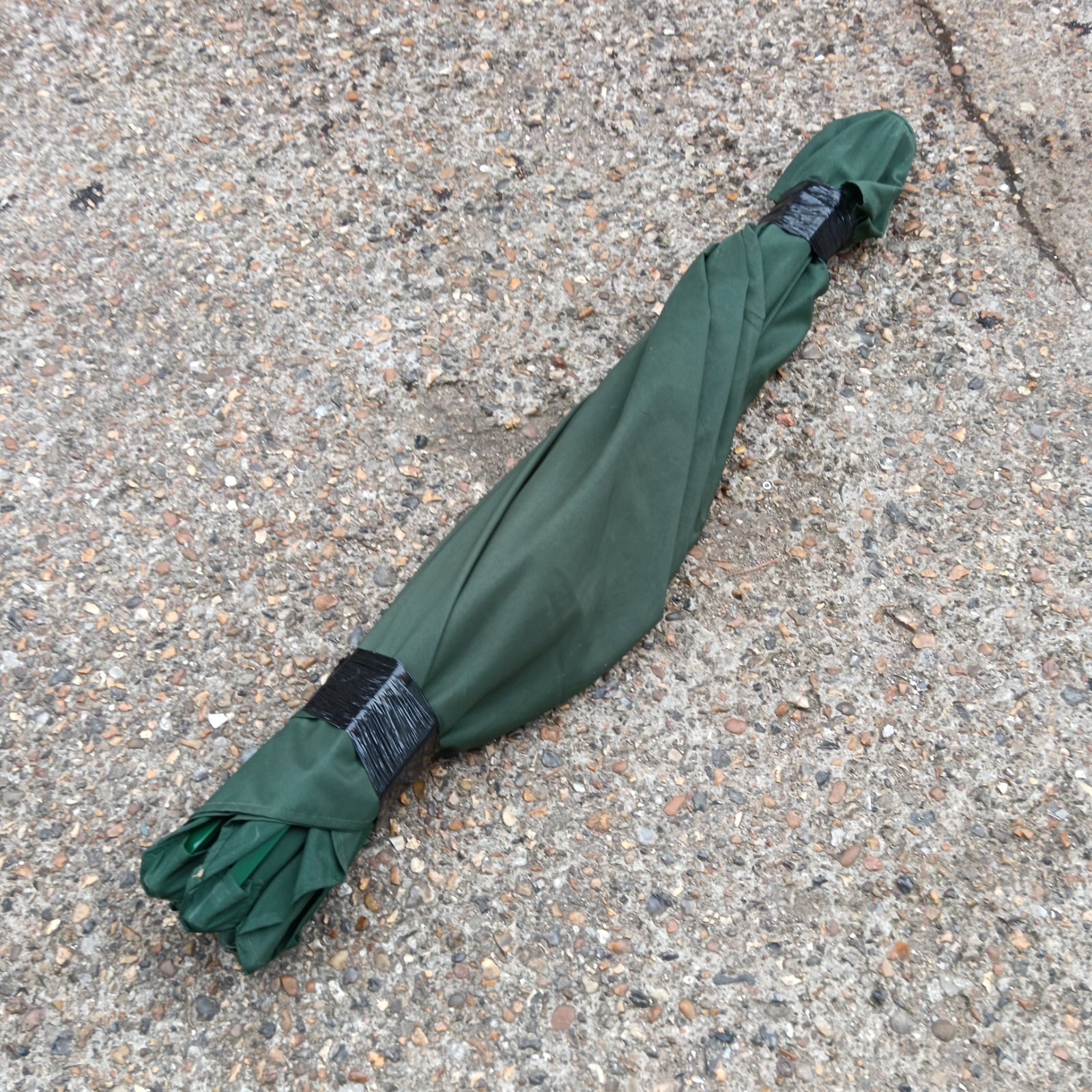 Bundled green garden parasol for outdoor shade.