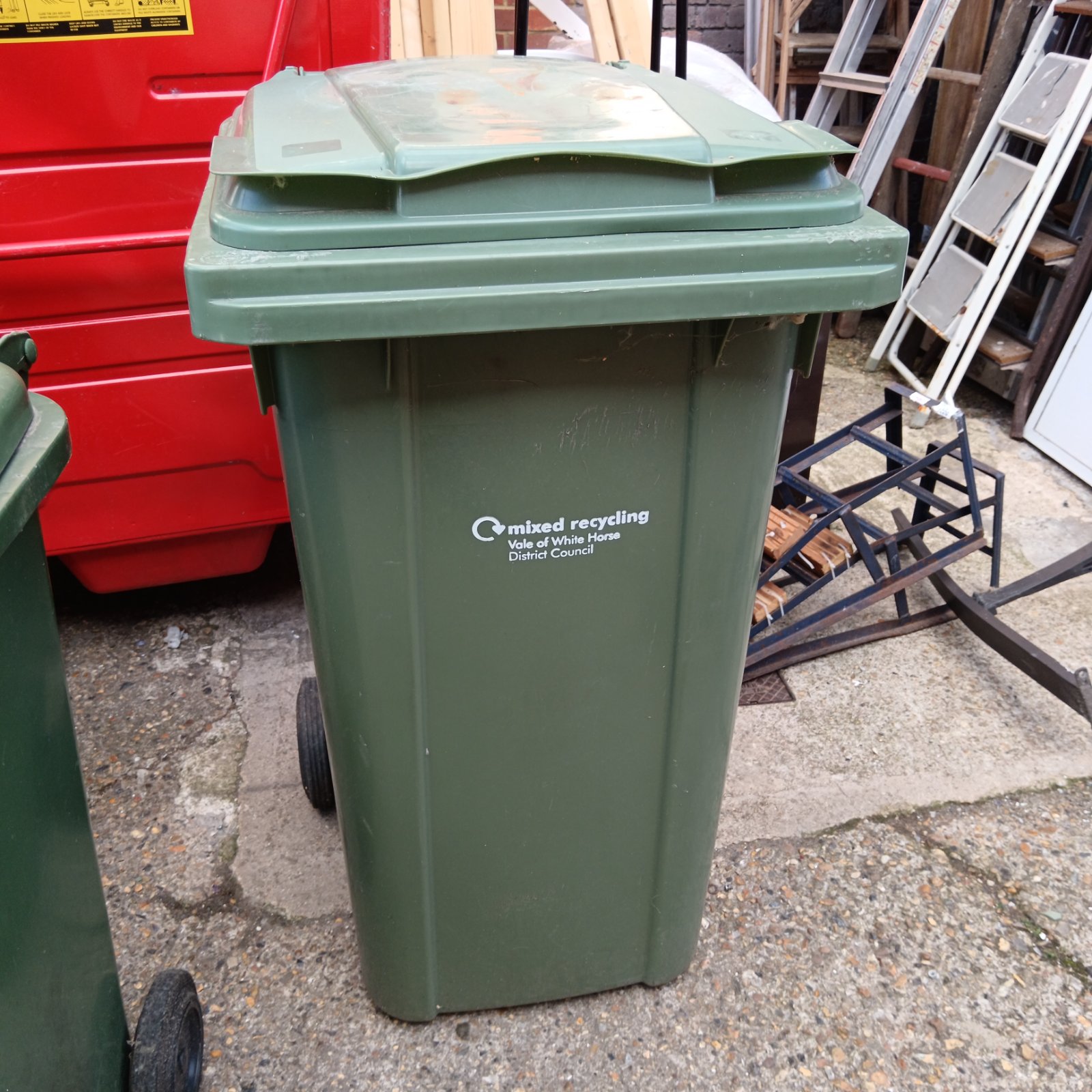 Large green wheelie bin for garden waste and recycling.