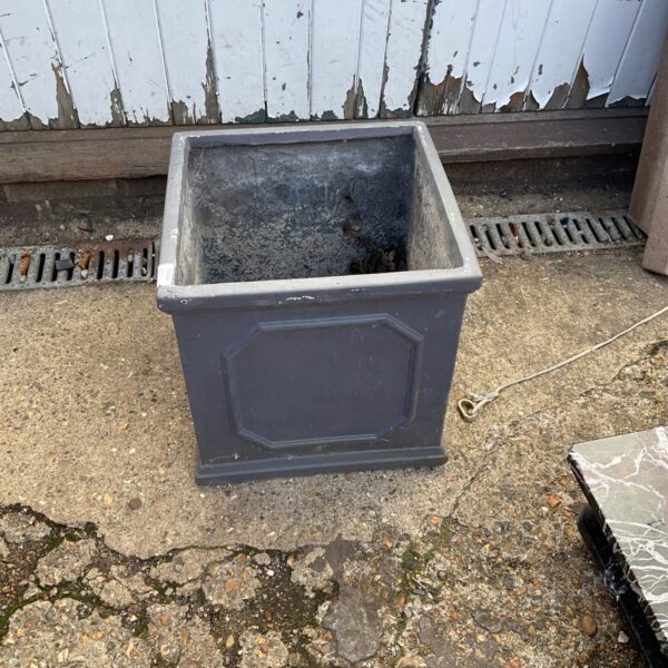 Dark grey square garden planter with decorative panels.