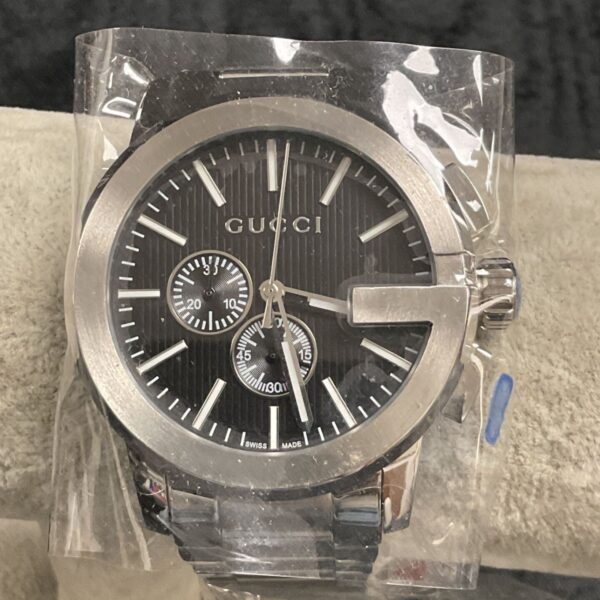 Close-up of a Gucci reproduction wristwatch with a black dial.