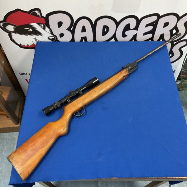 Haenel air rifle with Nikko scope and wooden stock on blue table