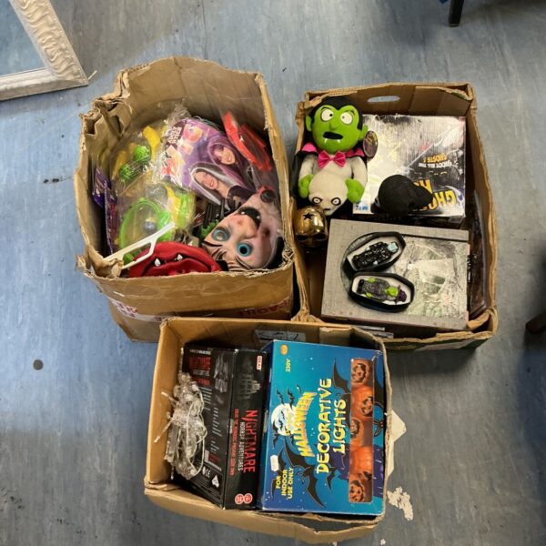 Three boxes of Halloween items including masks, plush vampire and decorative lights