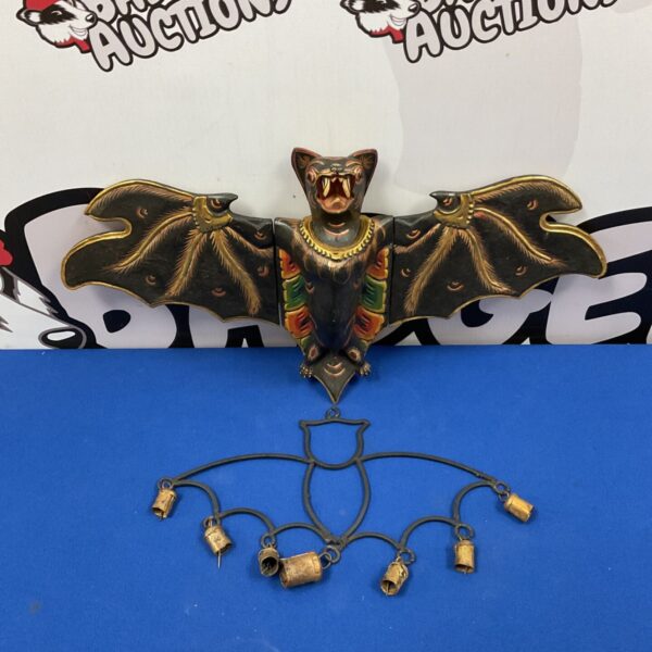 Hand painted carved wooden bat with metal bells.