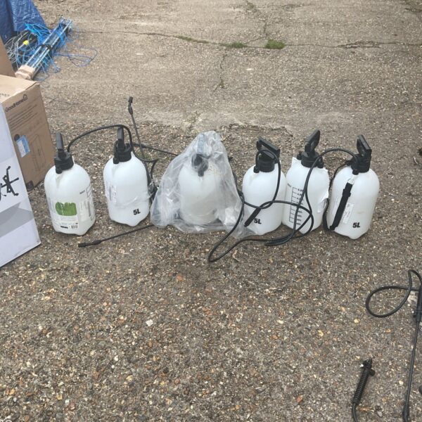 Collection of used hand sprayers for garden and agricultural use.