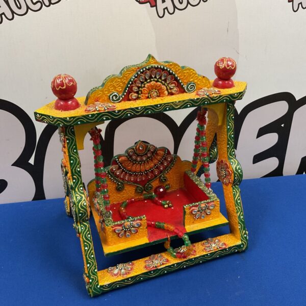 Handcrafted painted wooden Krishna swing with kundan stone work and red beaded garlands