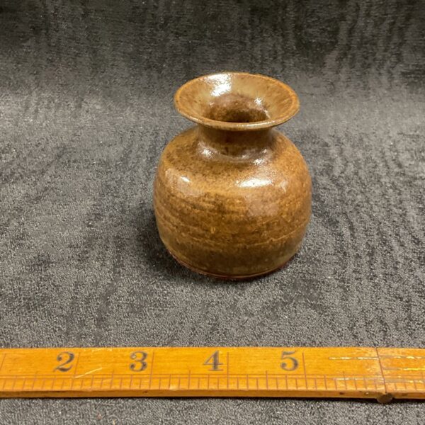 Small handmade ceramic brush pot with a brown glaze.