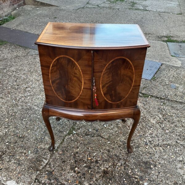 Antique Harrods media cabinet with inlaid doors and curved front.
